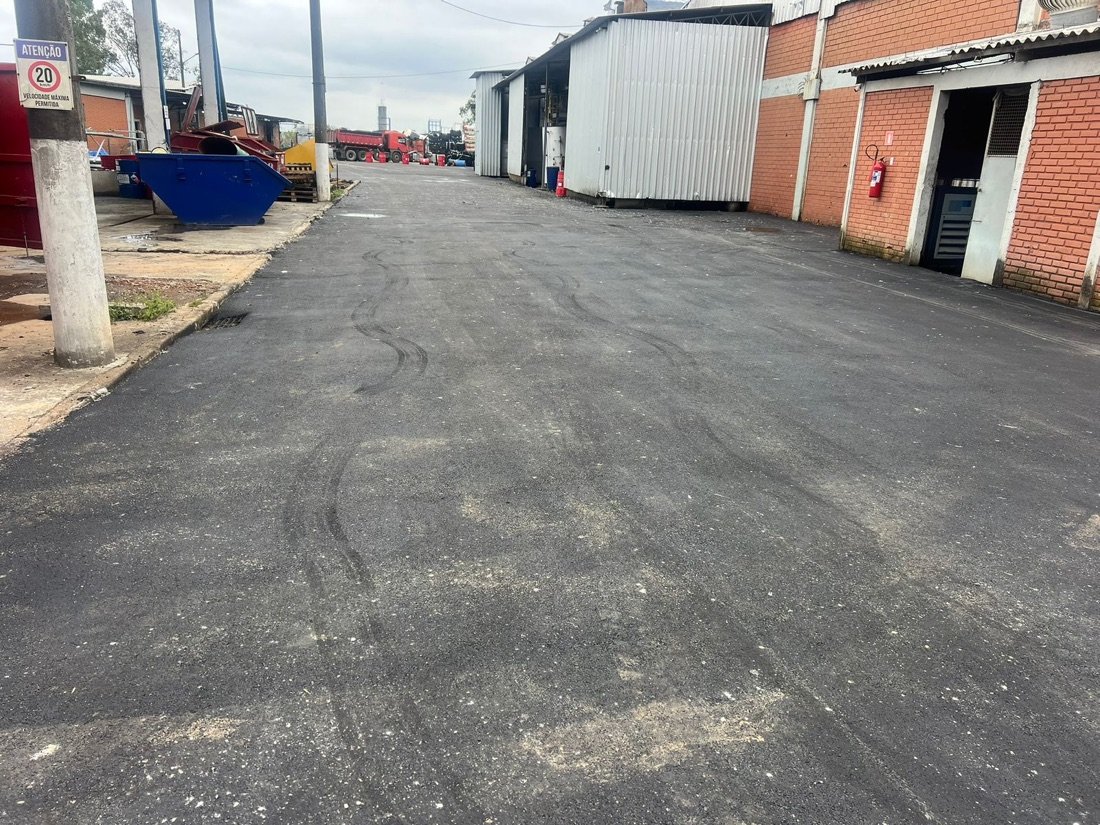 Acesso industrial pavimentado, com sinalização para caminhões
